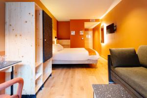 a hotel room with a bed and a couch at Hob Orelle - Les 3 Vallées Val Thorens in Orelle +71 photos
