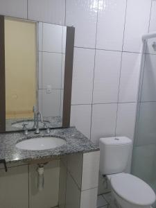 a bathroom with a toilet and a sink and a mirror at Próximo ao centro de Cotia in Cotia