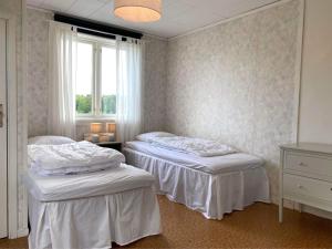 two twin beds in a room with a window at Fully equipped country house with lake location in Eksjö