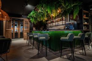 un bar avec des tabourets et des plantes verts dans l'établissement Hôtel Anne de Bretagne, à Saint-Malo
