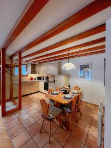 a large kitchen with a wooden table and chairs at Apartment Aphrodite West magnificent Eiger view in Grindelwald