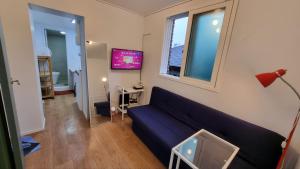 a living room with a blue couch and a tv at Namsan Ville in Seoul