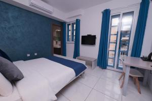 a bedroom with a bed and a desk and a tv at The Exiles Hotel in Sliema