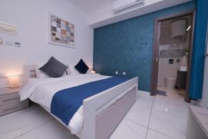 a bedroom with a large bed and a blue wall at The Exiles Hotel in Sliema