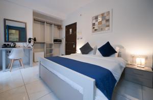 a bedroom with a large bed and a kitchen at The Exiles Hotel in Sliema