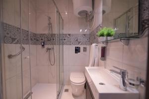 a bathroom with a shower and a toilet and a sink at The Exiles Hotel in Sliema