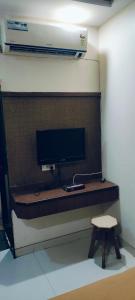 a desk with a monitor and a stool in a room at Arihant palace in Shirdi