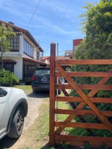 a wooden fence in front of a house at Fedes house in Villa Gesell +4 photos