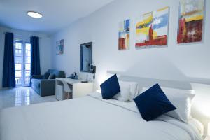 a bedroom with a large white bed with blue pillows at The Exiles Hotel in Sliema