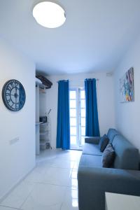 a living room with blue curtains and a blue couch at The Exiles Hotel in Sliema