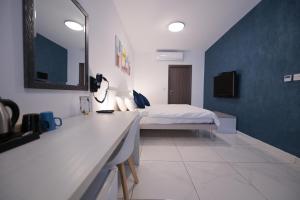 a bedroom with a bed and a vanity with a mirror at The Exiles Hotel in Sliema