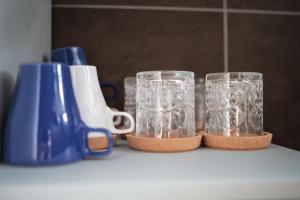 two clear glasses sitting on a counter next to a blue blender at B&B Villa Castriota in Torre Annunziata