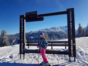 埃本塞Ferienhaus TraunseeStrand的站在雪地长凳旁边的一个年轻女孩