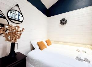 a bedroom with a white bed and a clock on the wall at Syrah - Cozy Apartment in Nice