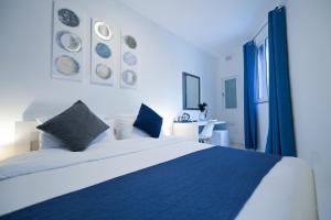 a bedroom with a large white bed with blue sheets at The Exiles Hotel in Sliema