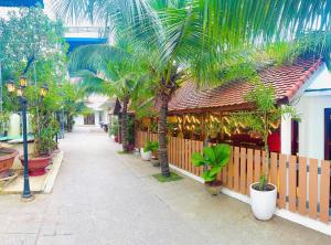 a courtyard with palm trees and a building with a fence at Sân Vườn Hotel Khánh Hòa in Ninh Hòa +40 photos