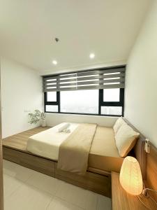 a bedroom with a large bed with a window at Hue Charm Apartment with Pool and Gym in Thôn Văn Dương