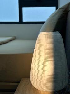 a lamp sitting on a table next to a bed at Hue Charm Apartment with Pool and Gym in Thôn Văn Dương +101 photos