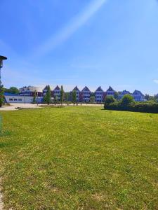 ein Grüngrasfeld mit Häusern im Hintergrund in der Unterkunft Mitteldeck 503 in Rechlin