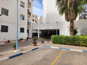 a building with a palm tree next to a street at Dar mayssane in Agadir