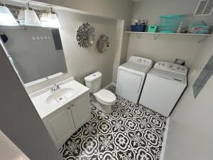 a bathroom with a toilet and a sink and a washer at Outer Banks Haven New Kitchen and New Outdoor Areas in Kitty Hawk Beach +53 photos