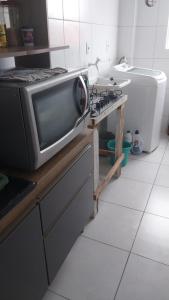 un forno a microonde appoggiato su un bancone in cucina di Apartamento grande a Navegantes