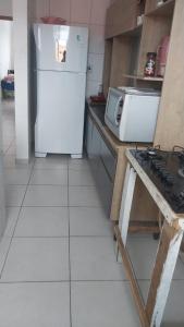 una cucina con un frigorifero bianco e una stufa di Apartamento grande a Navegantes