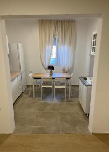 Una cocina con mesa y sillas y una ventana. en Trosobni apartman, en Belgrado
