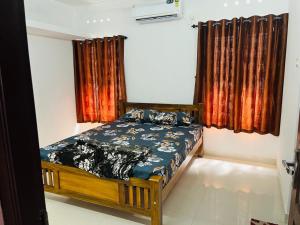 Un dormitorio con una cama y una ventana con cortinas. en Trivi Chackai Home Stay, en Trivandrum