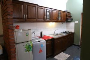 a kitchen with wooden cabinets and a white refrigerator at T51 Hanthane in Kandy