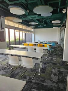 a classroom with tables and chairs in a room with windows at SerenityStayatRiveria KL Sentral in Kuala Lumpur +31 photos