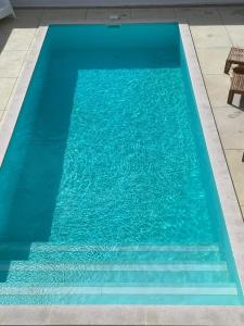 een zwembad met blauw water in een gebouw bij Casa Mikali in Alfeizerão