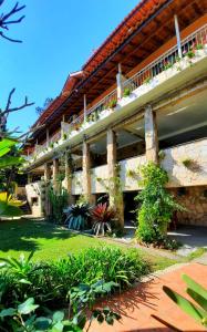 ein großes Gebäude mit Pflanzen an der Seite in der Unterkunft Pousada Canto das Corujas in São Roque