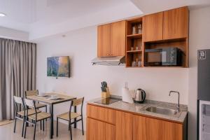 eine Küche mit Spüle und Tisch mit Stühlen in der Unterkunft 1 BR studio 777 Beach Condotel in Mai Khao Beach