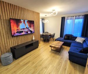 a living room with a blue couch and a table at Charming Apartments - Ski Arena Szrenica in Szklarska Poręba