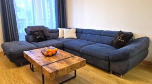 a blue couch in a living room with a table at Charming Apartments - Ski Arena Szrenica in Szklarska Poręba
