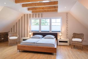 Un dormitorio con una cama con dos sillas y una ventana. en Ferienhaus Großer Vilm, en Putbus