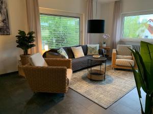 ein Wohnzimmer mit einer Couch und zwei Sesseln in der Unterkunft Cozy Apartment - 2 BR, Spacious Kitchen, Balcony, Top Location in Hemsbach + 2 Fotos