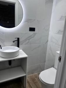 a white bathroom with a sink and a mirror at Casa Cuchariños Louro in Louro +26 photos