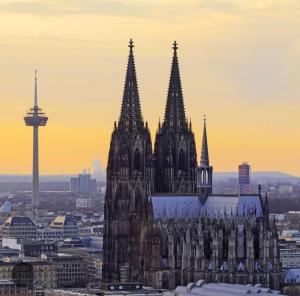 a large cathedral with a city in the background at DOMspitzen-BLICK, cooles 2 Zimmer Apt mit Indoor-Swimmingpool auf dem Dach, Küche und Smart-TV in Cologne