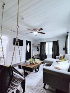 un columpio en una sala de estar con sofá en The Honeycomb Haven l 1 Mile to Downtown Thomasville, en Thomasville