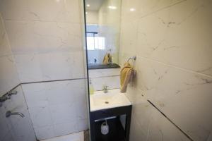 y baño de azulejos blancos con lavabo y ducha. en Carlos Calvo 633 Alojamiento, en Buenos Aires