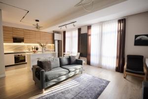 a living room with a couch and a kitchen at Lovely 1-bedroom rental unit in downtown in Dushanbe