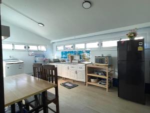a kitchen with a black refrigerator and a table at Crypto Home in Ban Mae Mao