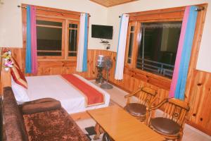 a hotel room with a bed and a table and a table sidx sidx at Anurag Hotel Chakrata in Chakrāta