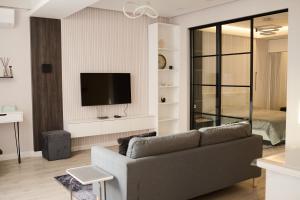 a living room with a couch and a flat screen tv at Lovely 1-bedroom rental unit in downtown in Dushanbe