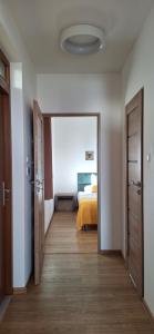 a room with a bedroom with a bed and an open door at Uroczysko nad Jeziorem Żywieckim in Zarzecze