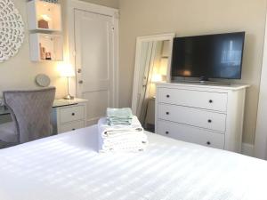 a bedroom with a bed with a tv and a dresser at Bella room near downtown Train I-95 & beaches in Stamford