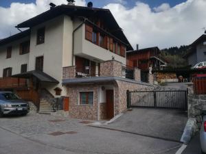 a building with a car parked in front of it at Appartamento in Val di Sole in Commezzadura +5 photos