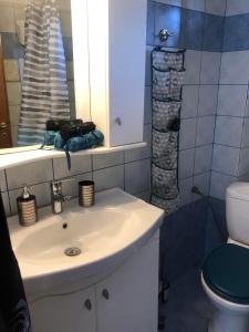 a bathroom with a sink and a toilet and a mirror at "STARDUST" Family House in Metamorfosi +46 photos